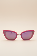 Front view of Sol Kyst cat eye sunglasses featuring bold pink acetate frames, and reflective nylon lenses.