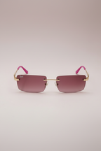 Barbie rimless sunglasses with pink tinted lenses, gold accents, and pink ear tips.