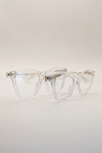 Two pairs of women's blue light glasses with clear lenses and clear frames with gold accents.