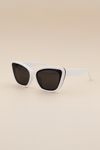 White cat-eye sunglasses with dark lenses on a beige background