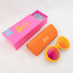Barbie Sol Kyst round orange sunglasses with pink reflective lenses, displayed with matching case and pink box.