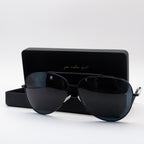 Sol Kyst women's aviators with black frames and dark tinted lenses in front of matching case with a white background.