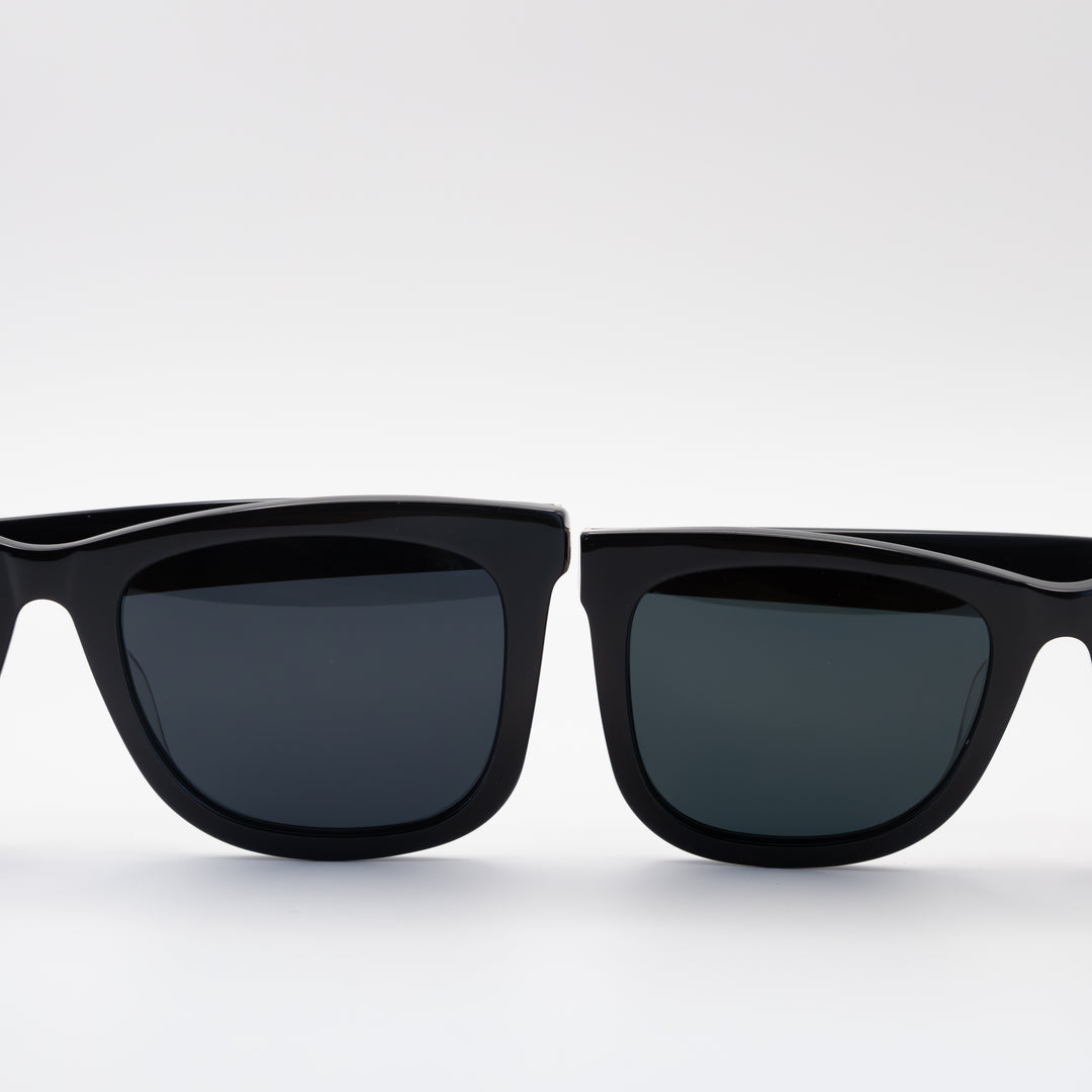 Close-up of two pairs of black sunglasses with sleek, rectangular frames and dark lenses, displayed side by side.