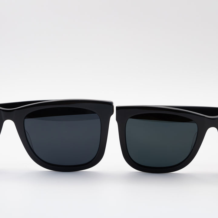 Close-up of two pairs of black sunglasses with sleek, rectangular frames and dark lenses, displayed side by side.