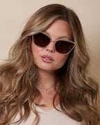 Woman wearing sunglasses with a neutral background