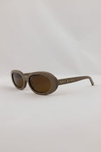 Brown sunglasses with 'Sole Society' branding on a light gray background