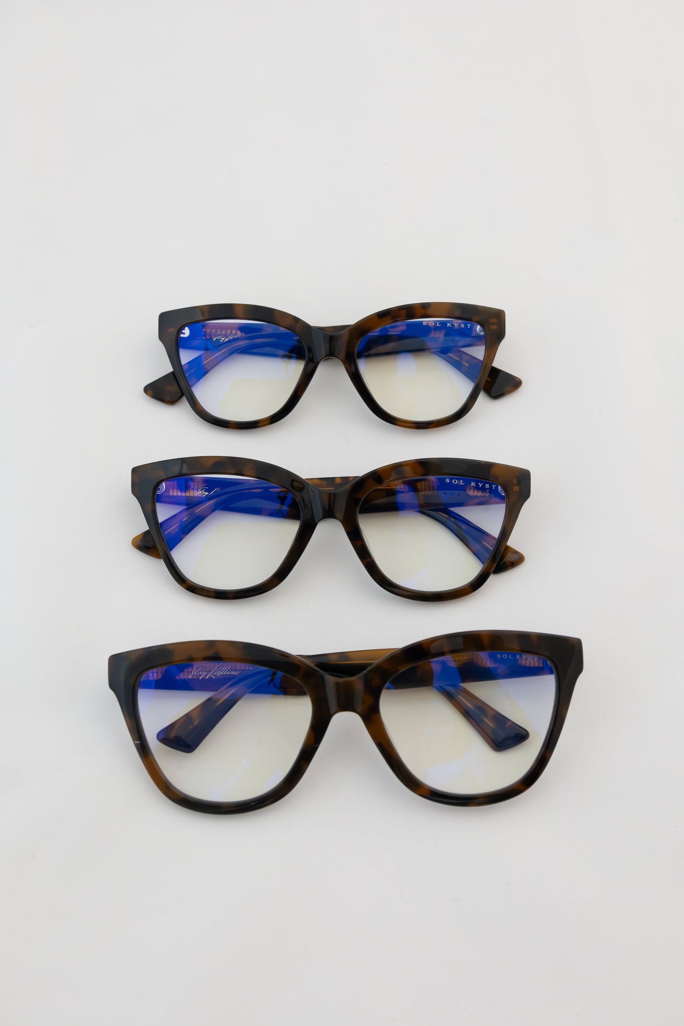 Three women's blue light glasses with tort frames, with blue showing in clear lenses.