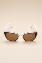 Top angle view of Sol Kyst women's cat eye sunglasses with white frames and brown tinted lenses.