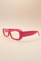 Pink sunglasses with 'SOL RYST' branding on a beige background