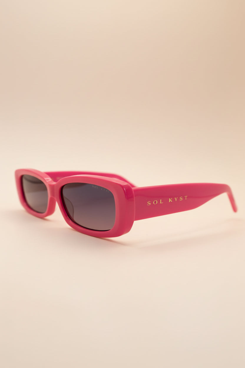 Pink sunglasses with 'SOL RYST' branding on a white background