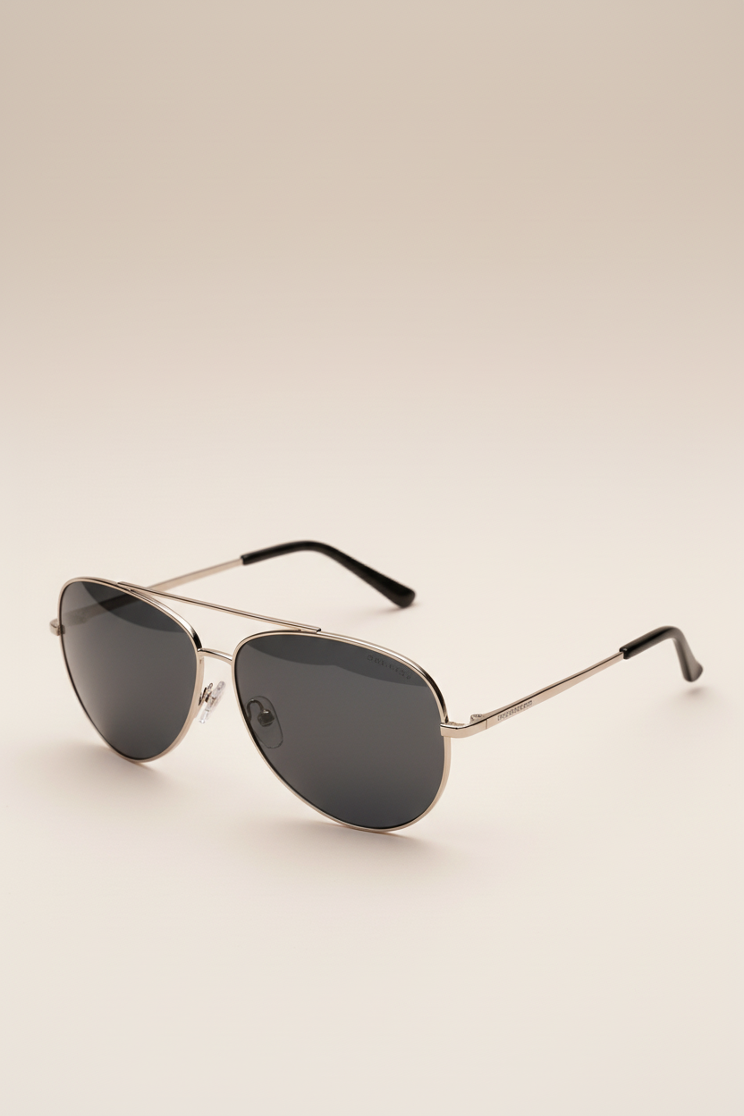 Aviator sunglasses with dark lenses on a beige background