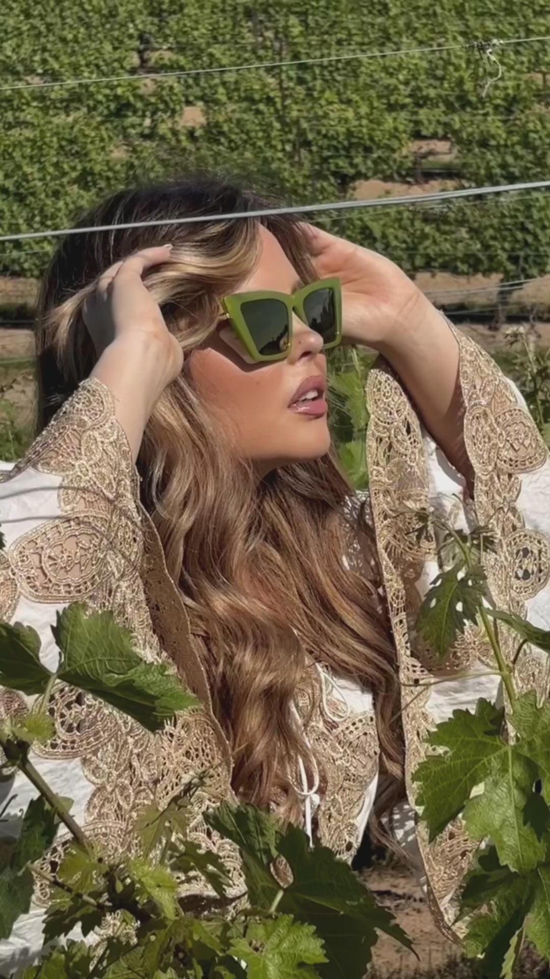 Photoshoot of women in a garden posing with Sol Kyst trapezoid sunglasses with green frames.
