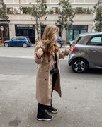 Women walking down the street with black Sol Kyst "Kyst Klip" attached to tan coat.