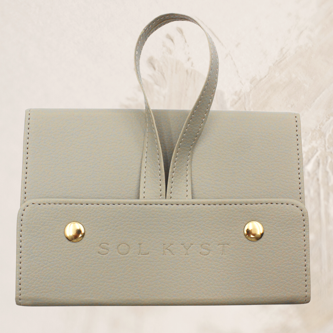 travel case for sunglasses or glasses, snap closure, strap for hanging or holding, beige leather, gold snaps, four slot - shown on a cream coloured background